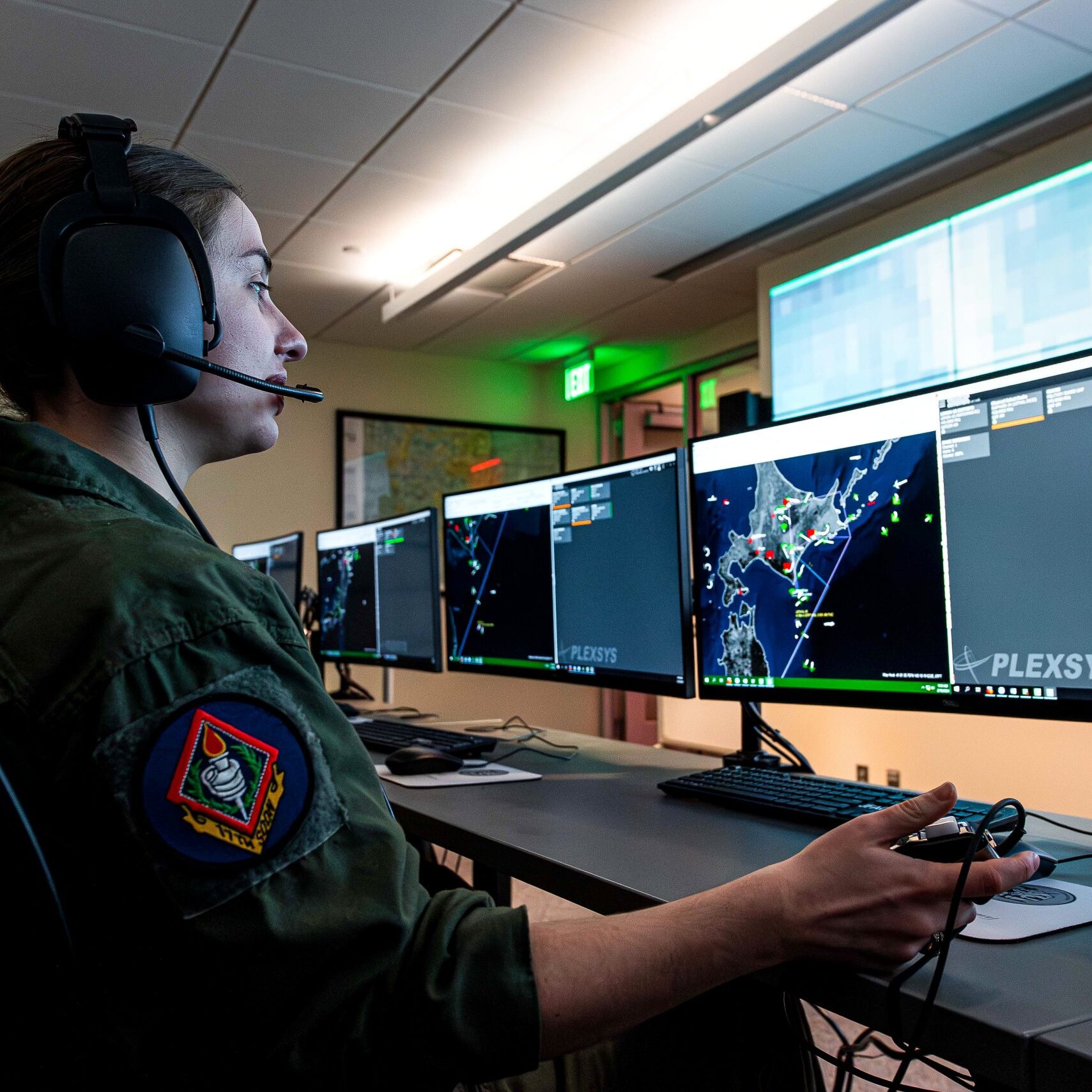 individual wearing a headset and looking at multiple computer monitors
